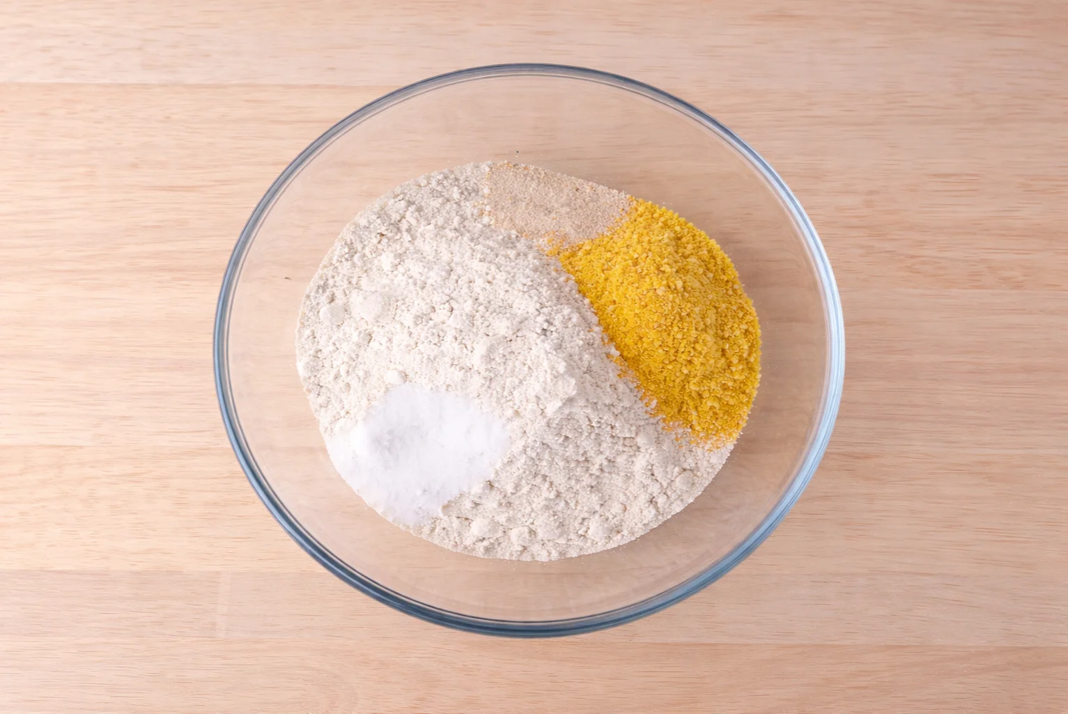Flour, yeast, ground nachos and salt mixed in a glass bowl before kneading