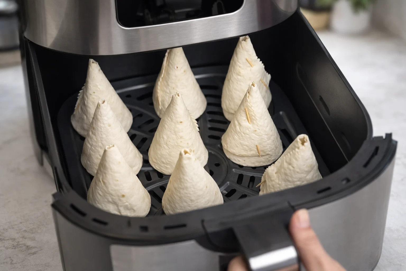 Unfilled tortilla cones placed in air fryer basket before baking