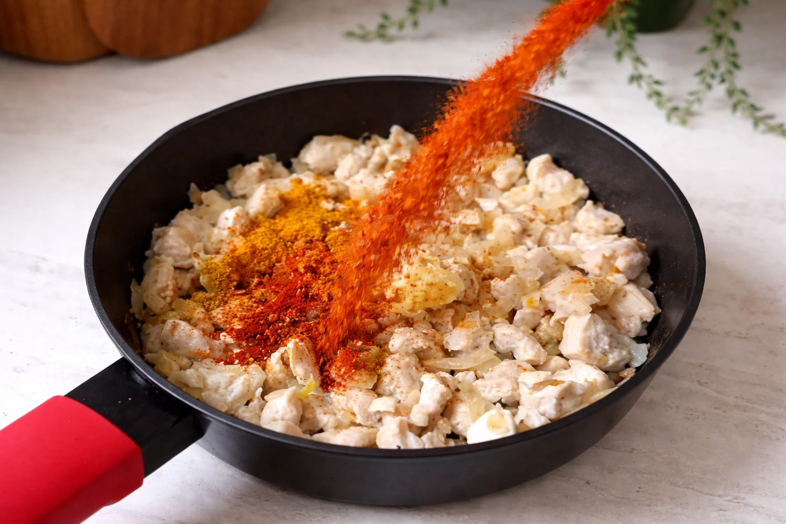 Seasoning chicken with spices while cooking