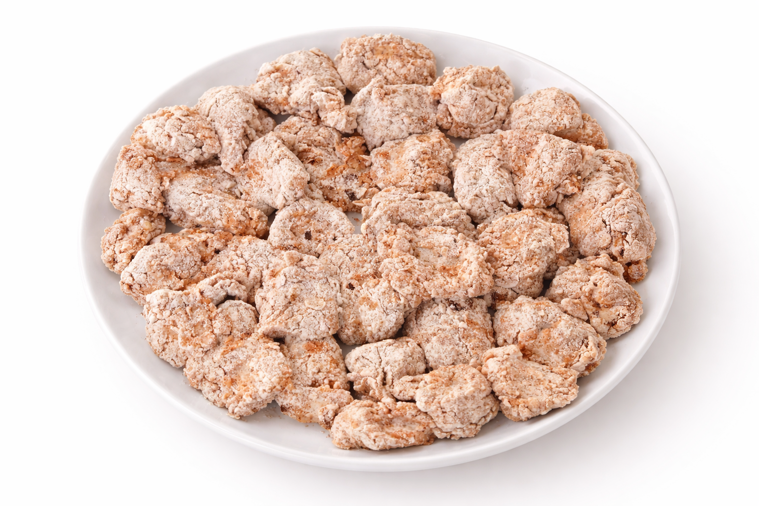 Flour coated chicken bites arranged on a plate before frying