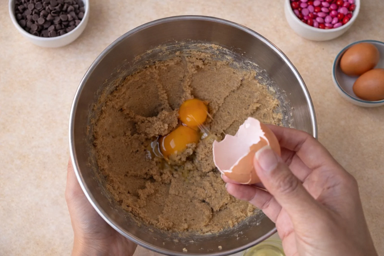 Egg and egg yolk being mixed into cookie dough