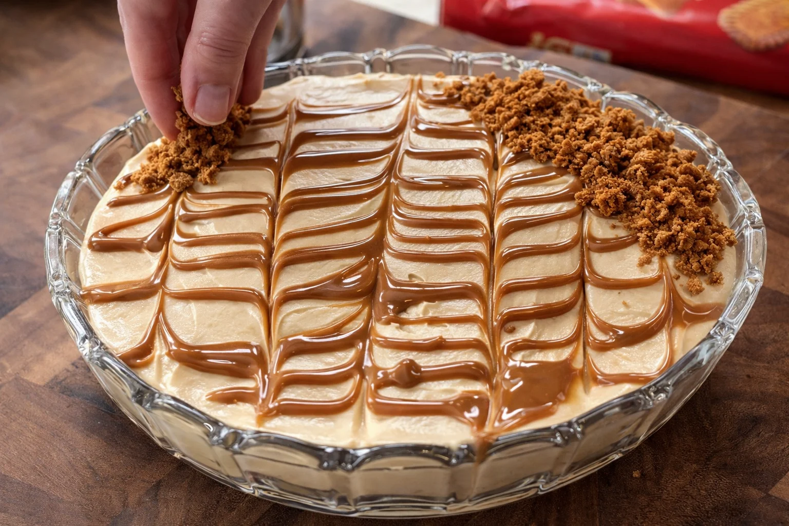 Lotus Biscoff biscuits arranged in a single layer over creamy mascarpone filling in a glass dish
