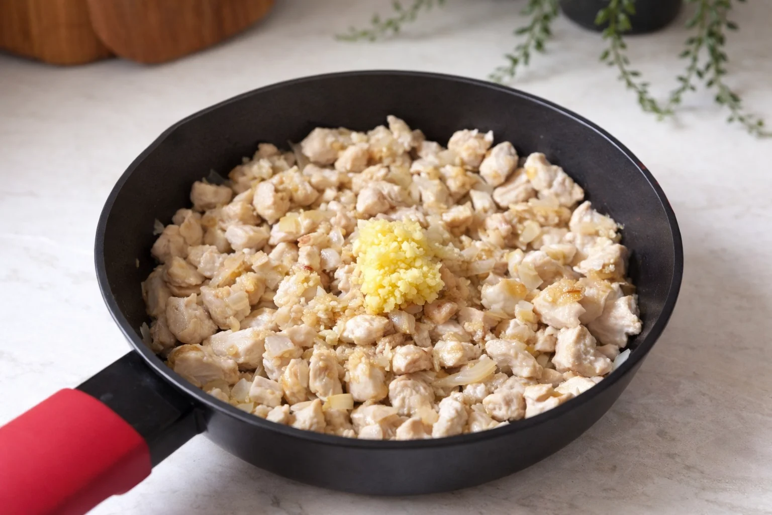 Adding fresh minced garlic to chicken mixture