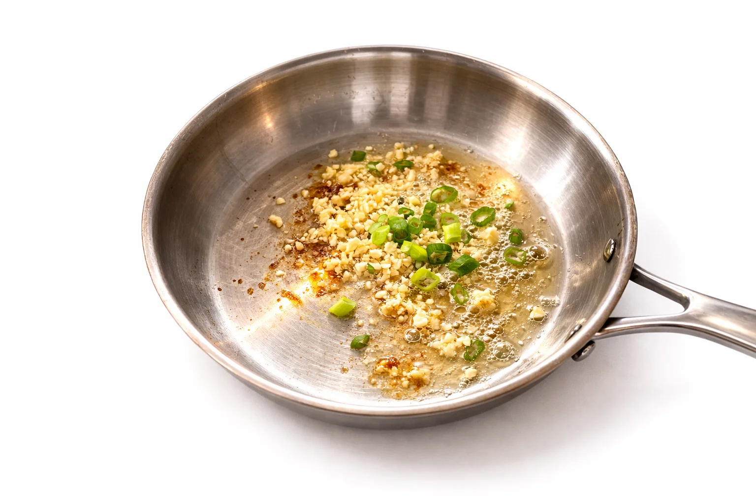 Garlic and green onions sautéing in pan for honey garlic sauce