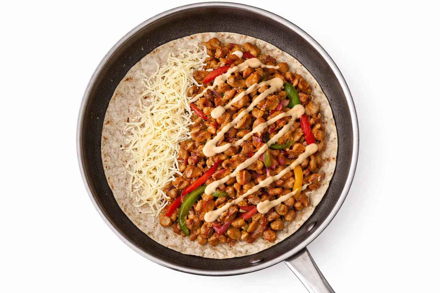 Flour tortilla layered with shredded cheese seasoned chicken filling and creamy chipotle sauce in skillet