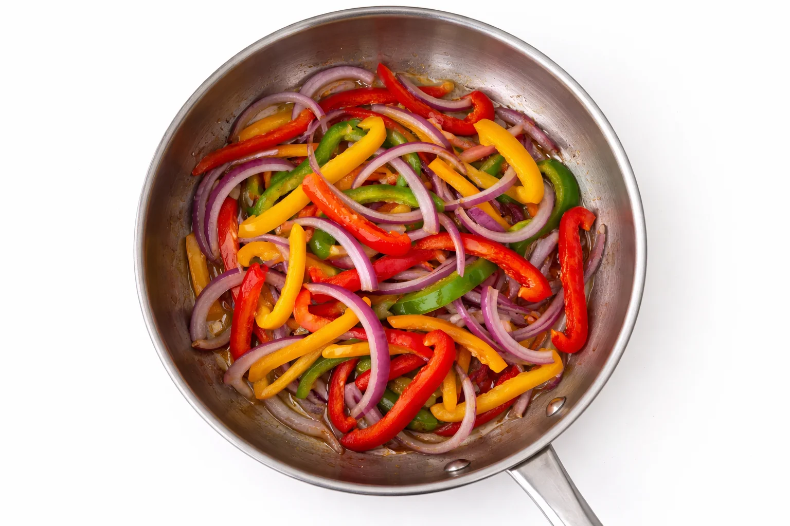 Sliced bell peppers and red onions sautéing in a skillet for chicken quesadilla filling