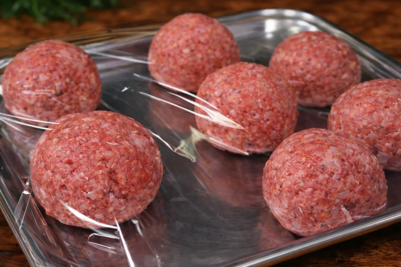 Raw meatballs shaped and placed on a tray