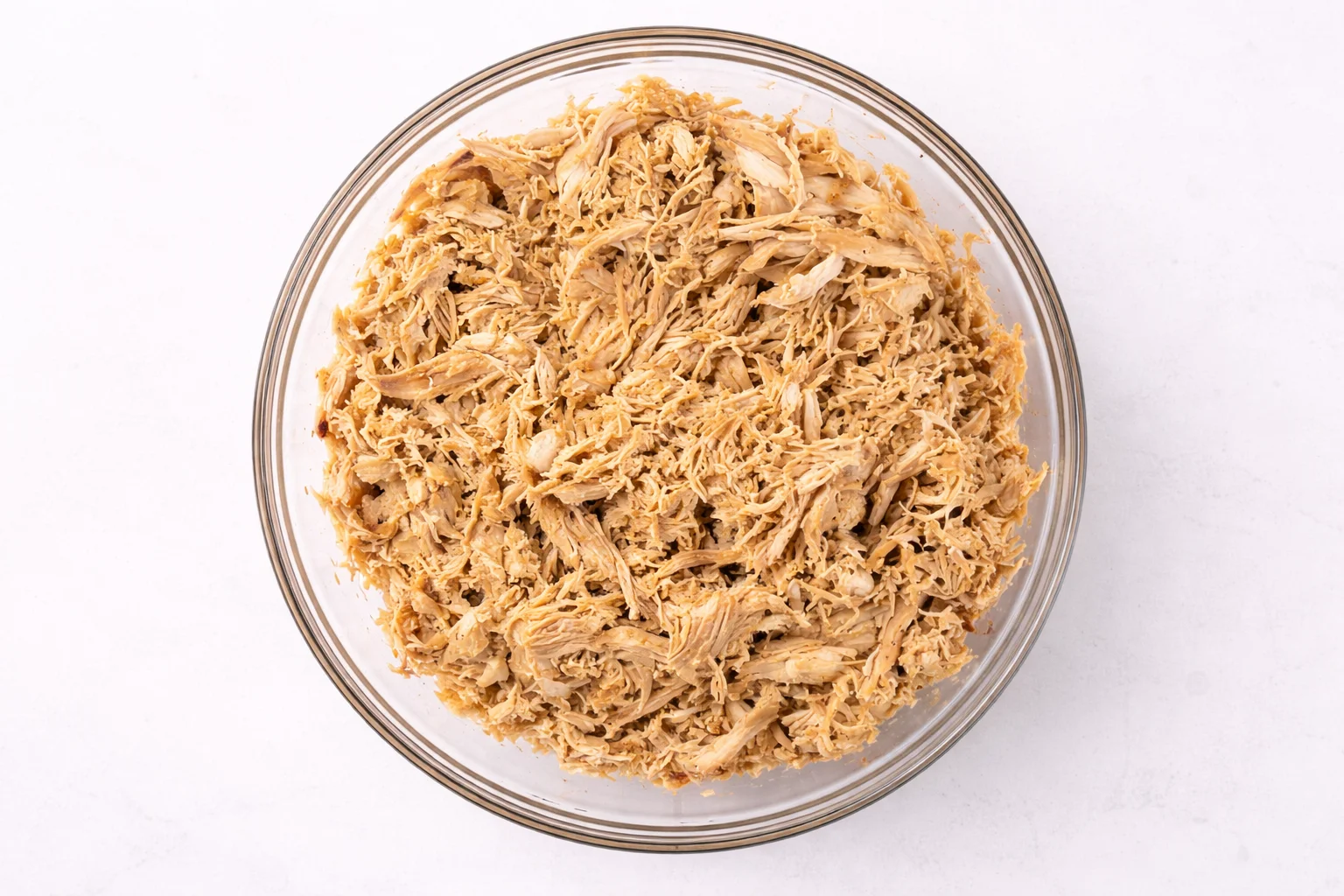 Freshly shredded chicken in bowl for Buffalo Chicken Sliders filling