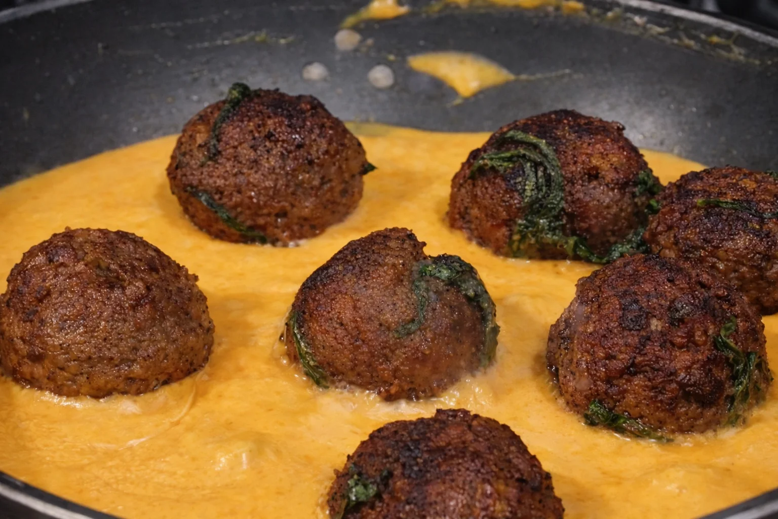 Meatballs placed into creamy sauce