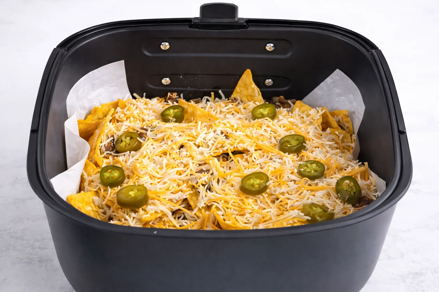Black beans and salsa verde are added across the nachos to bring extra texture and a fresh tangy flavor.