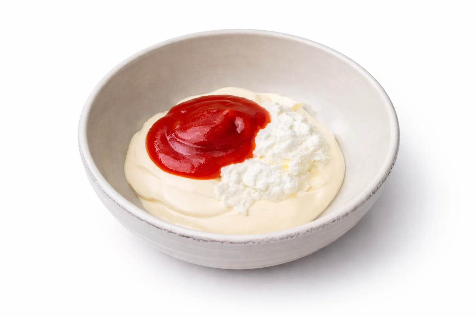 Greek yogurt and ketchup added to mayonnaise in a bowl for a healthier Cane’s style dipping sauce.