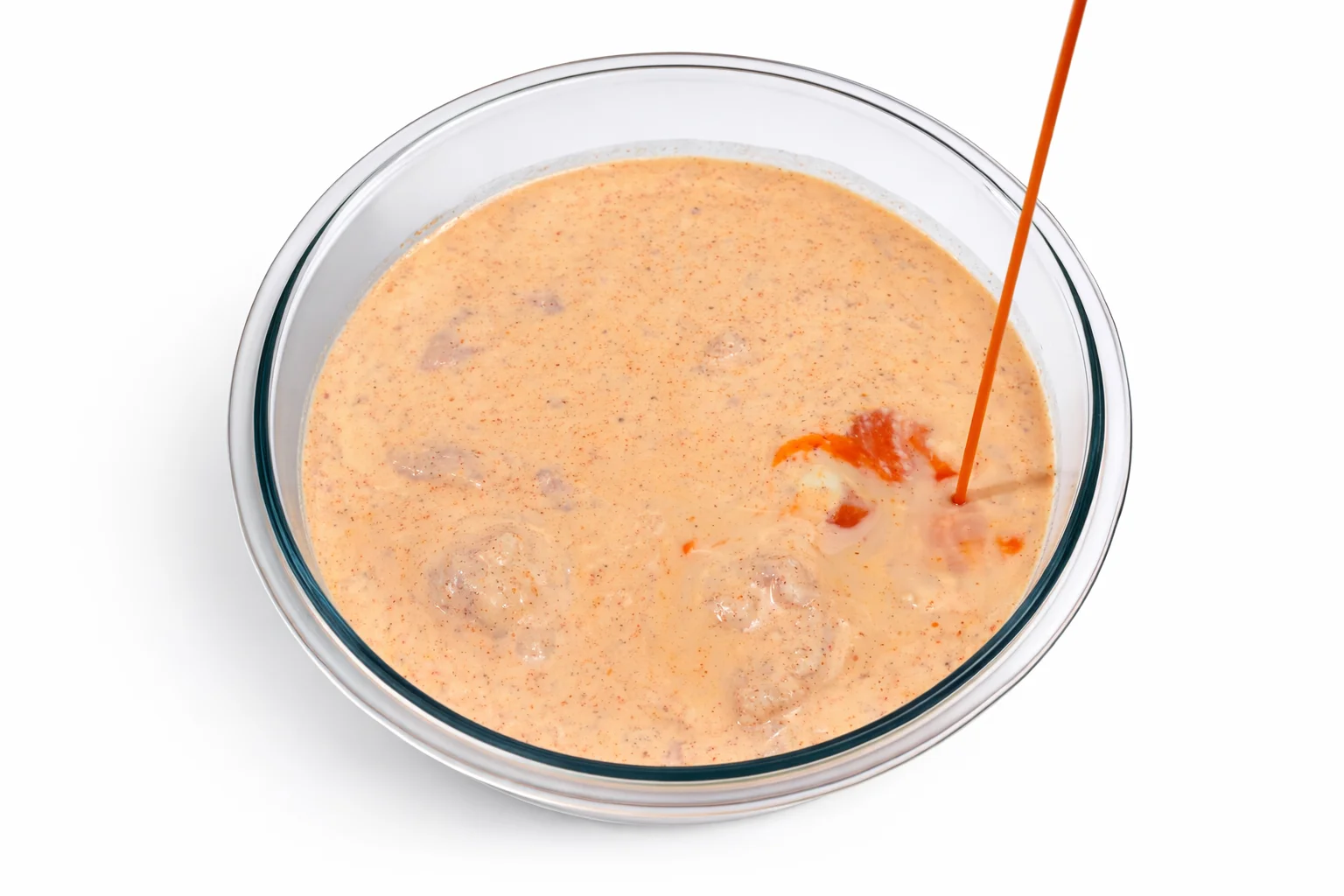 Hot sauce poured into chicken buttermilk marinade