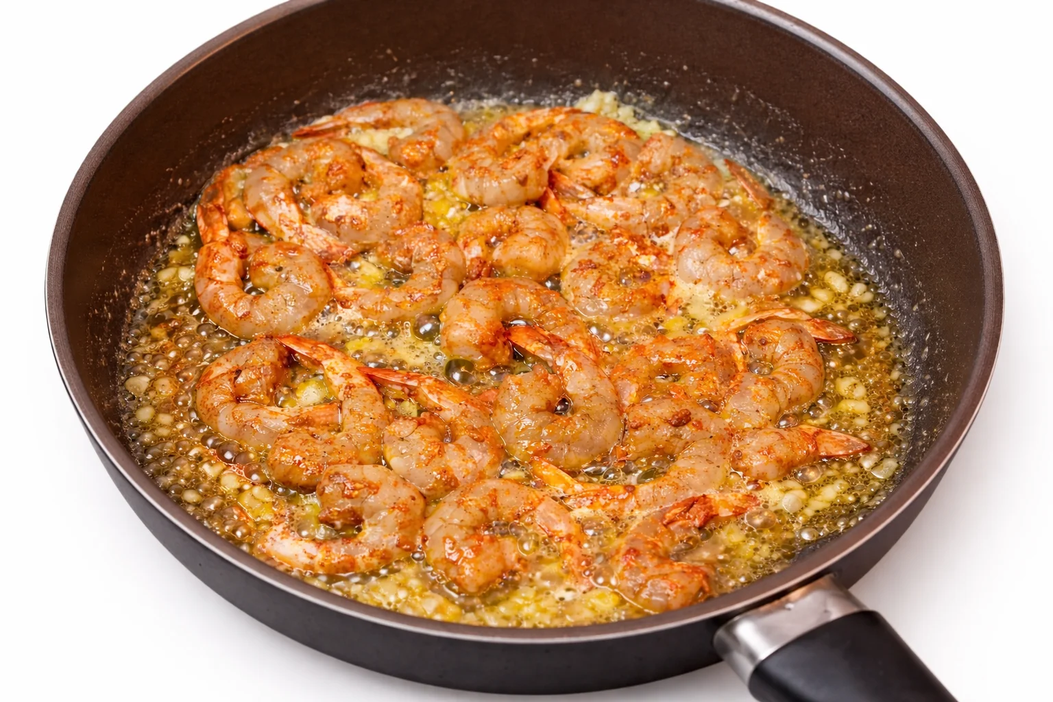 shrimp cooking in garlic butter sauce in skillet