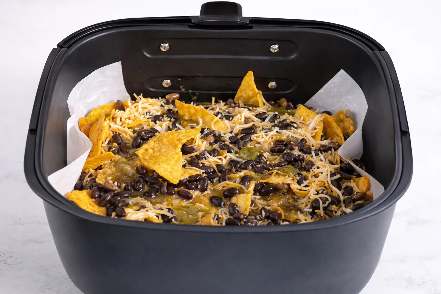Seasoned ground beef is spooned over the chips adding rich taco flavor and helping create the first layer.