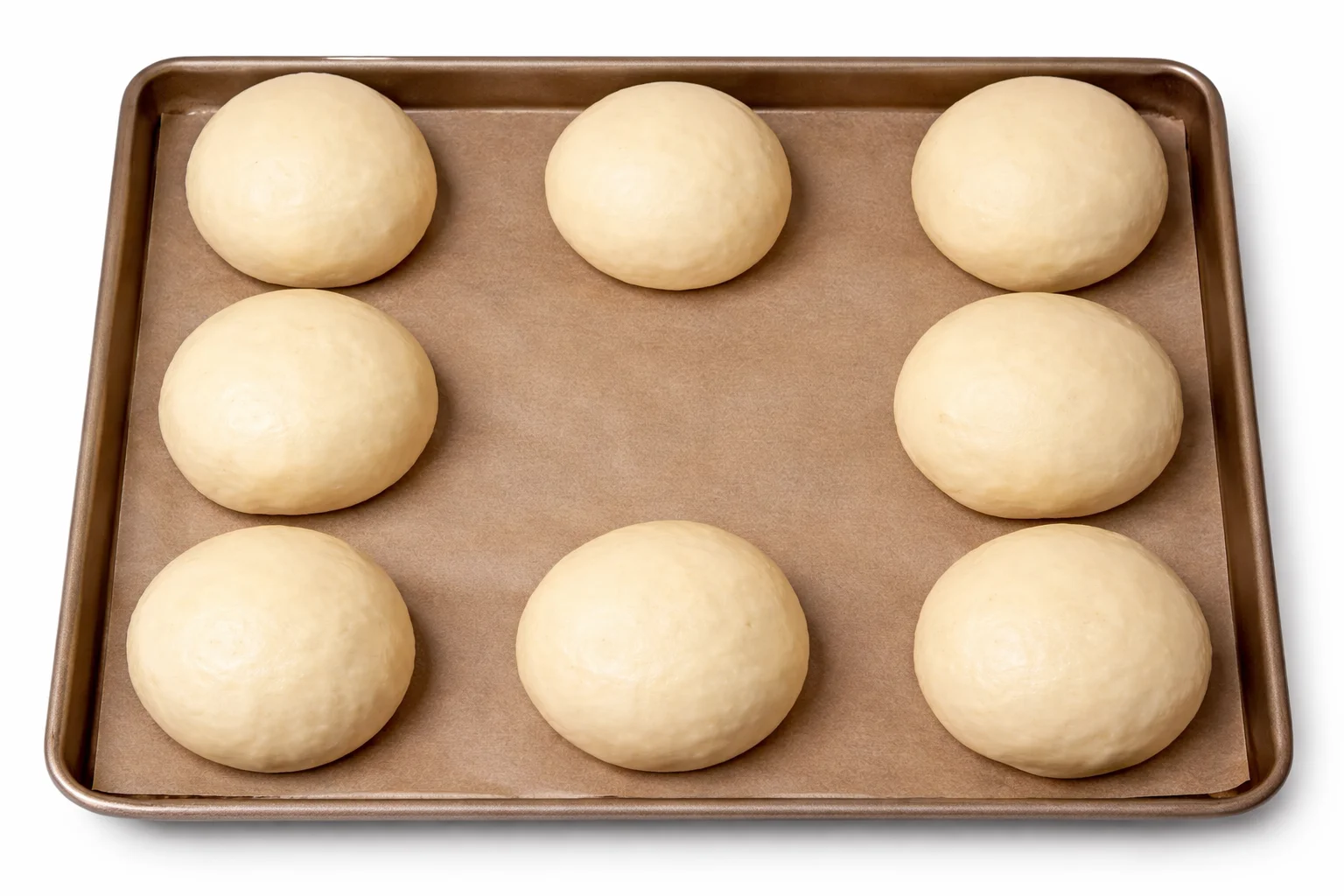 Slider dough balls resting on a baking tray before baking