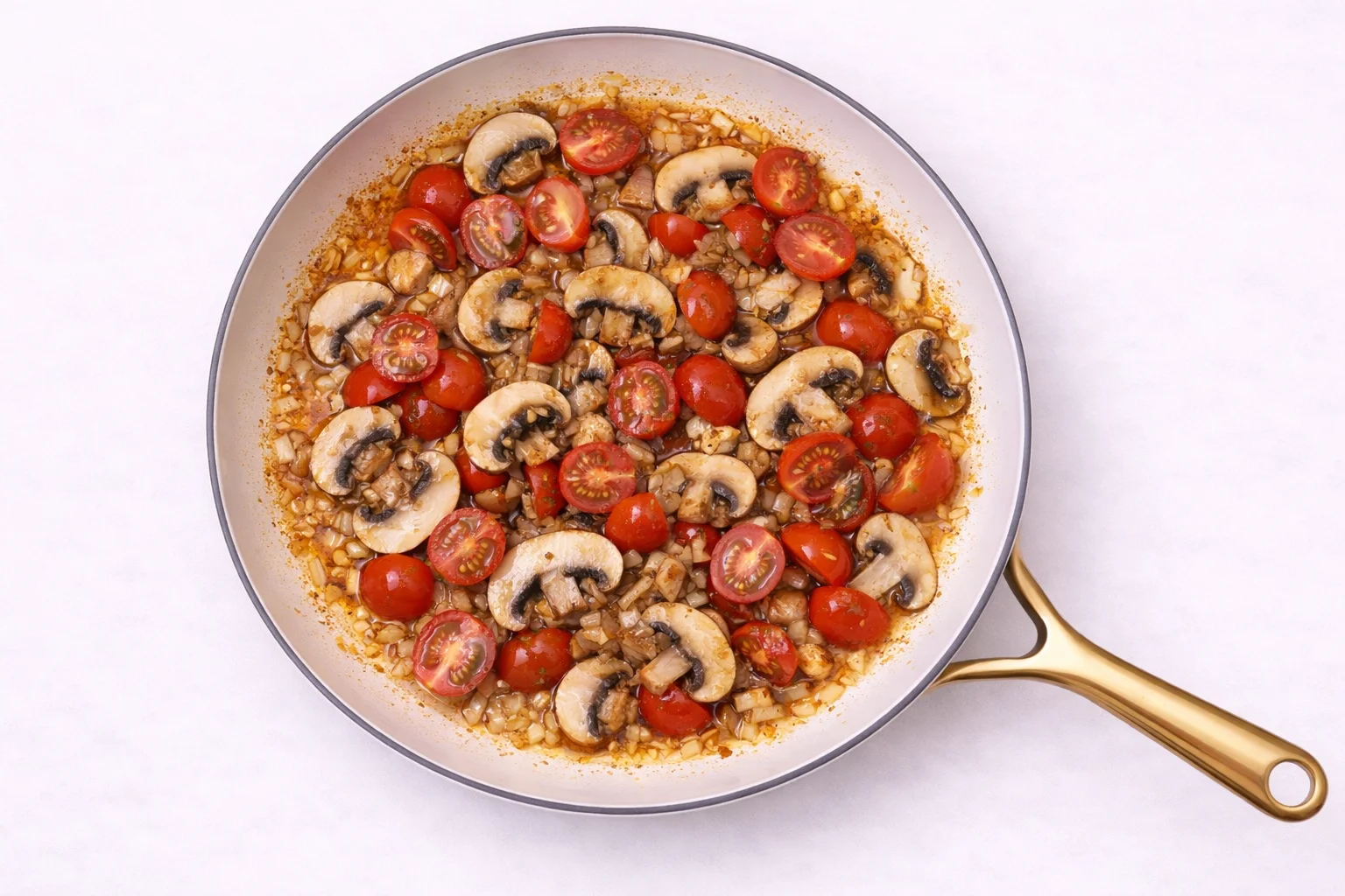 mushrooms and cherry tomatoes cooking together in skillet for creamy tuscan chicken