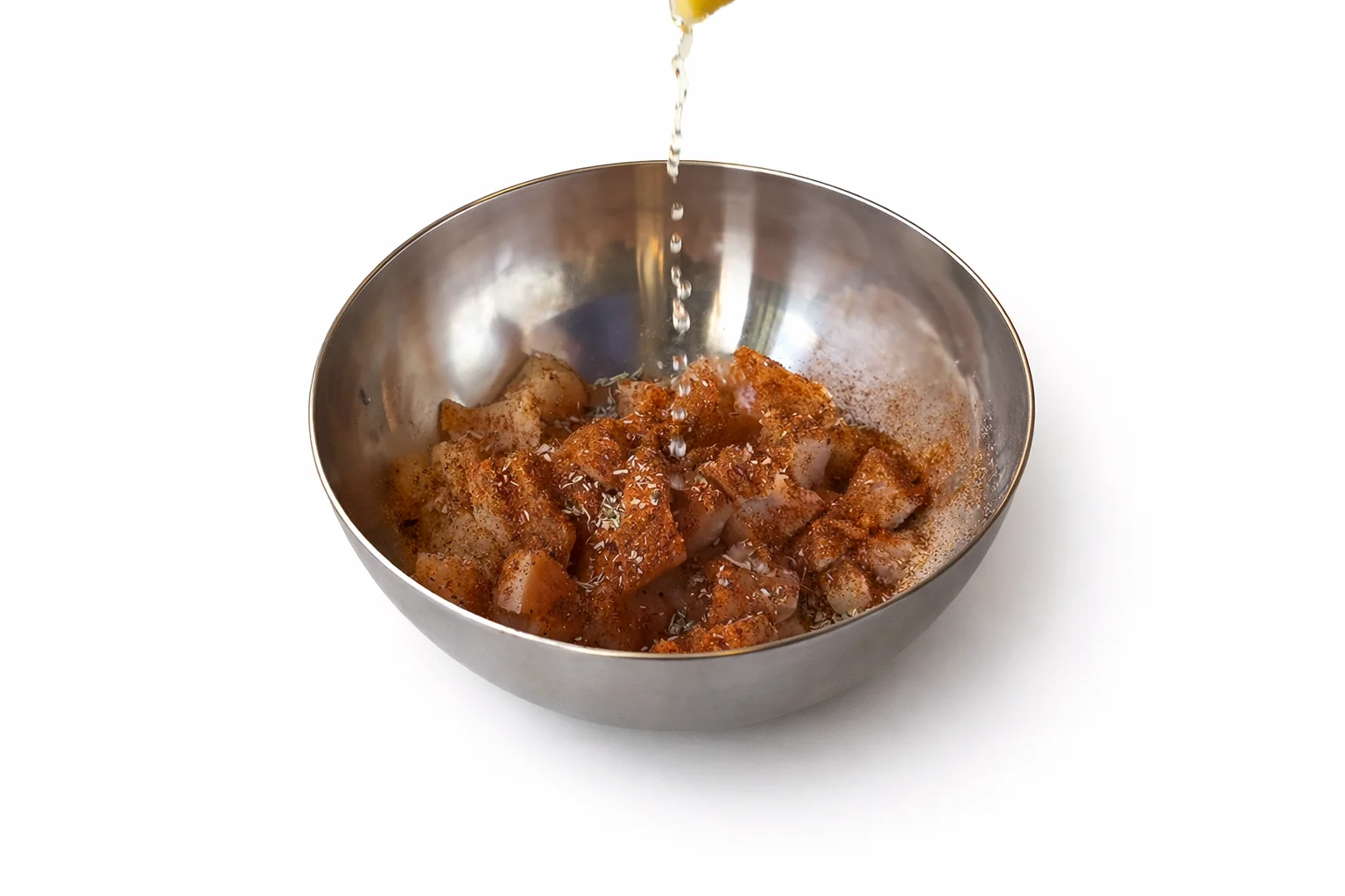 diced chicken seasoned with paprika cumin chili powder garlic powder and oil in a mixing bowl
