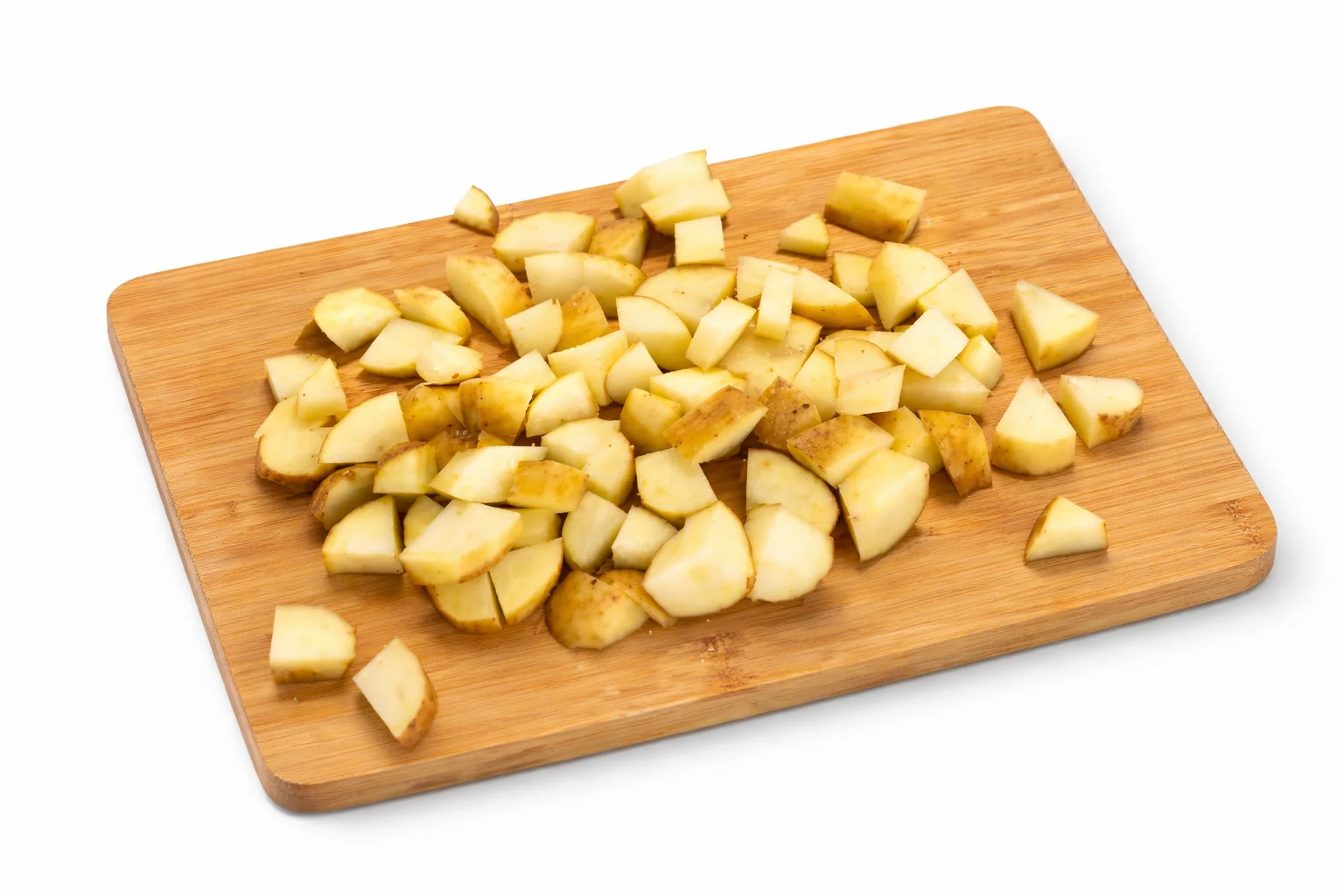 air fryer cheesy potato bites recipe step 1 cutting potatoes into small cubes on a wooden cutting board