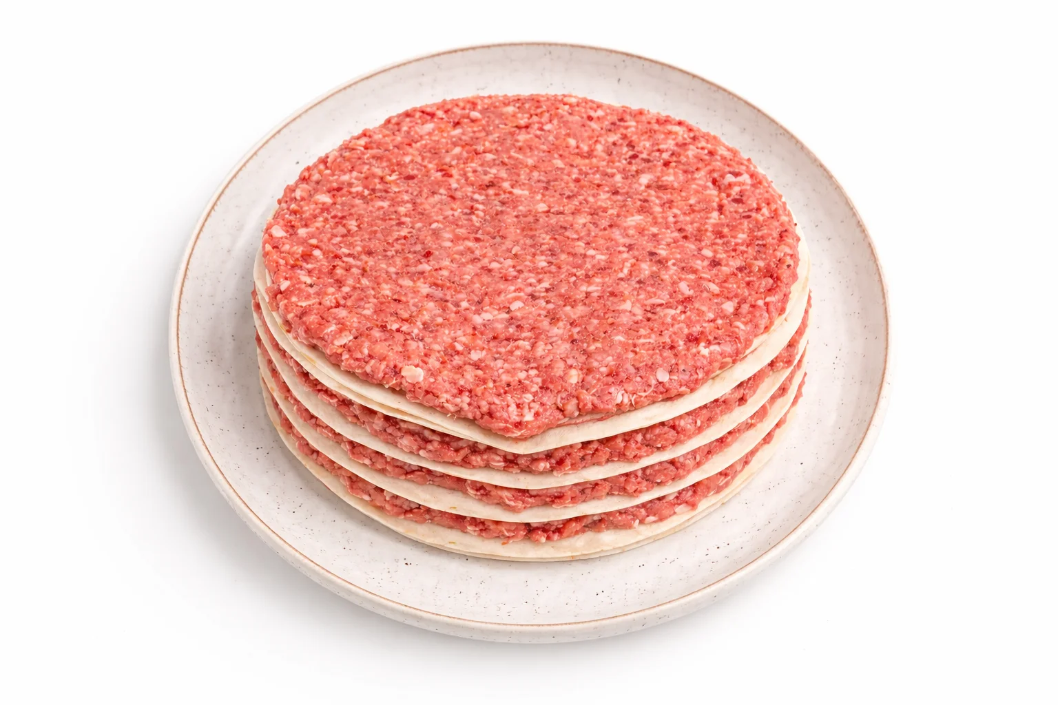 layers of flour tortillas with breakfast sausage stacked on a plate before shaping into breakfast tortilla cones