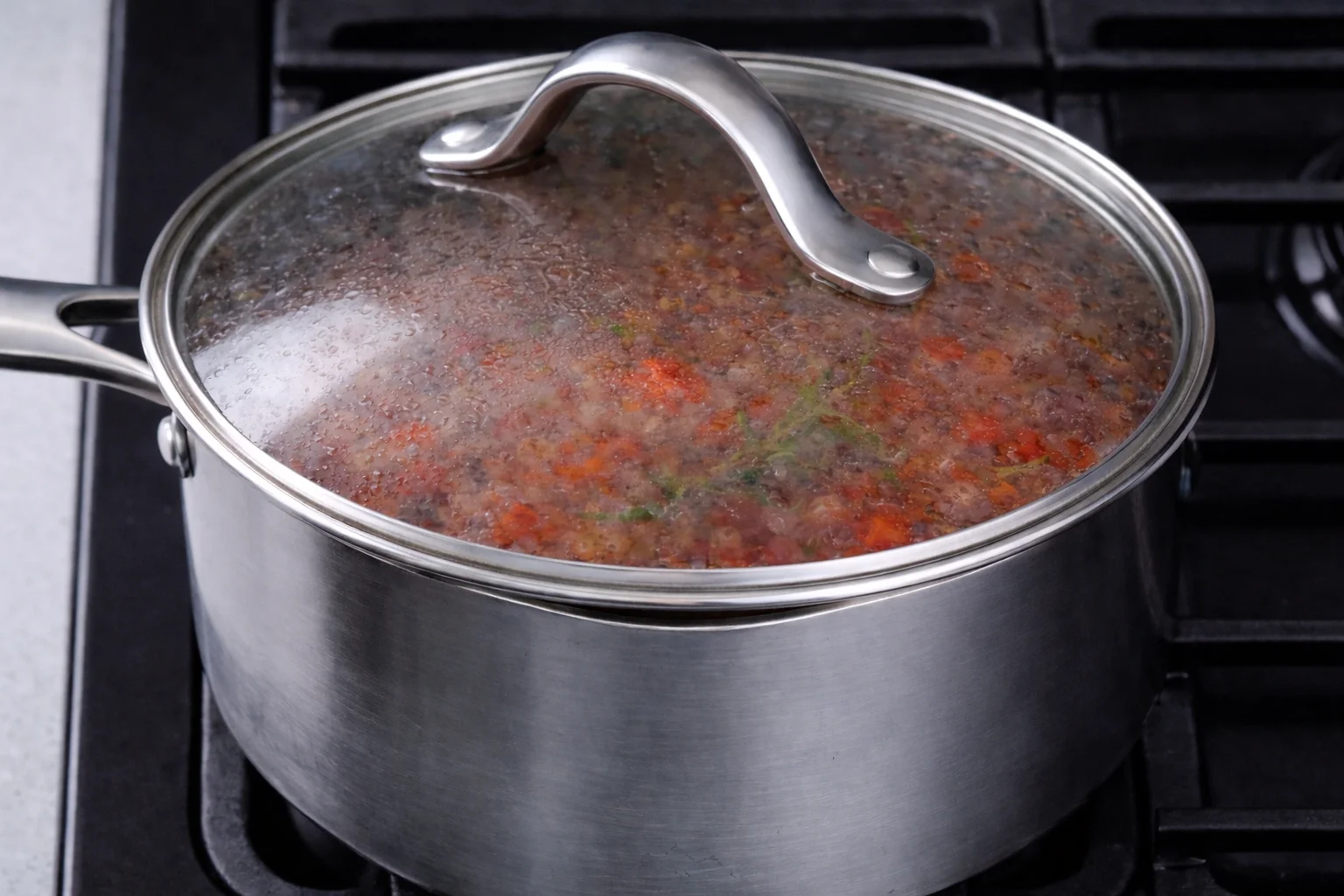 ground beef tomato sauce simmering in covered pot for casserole recipe