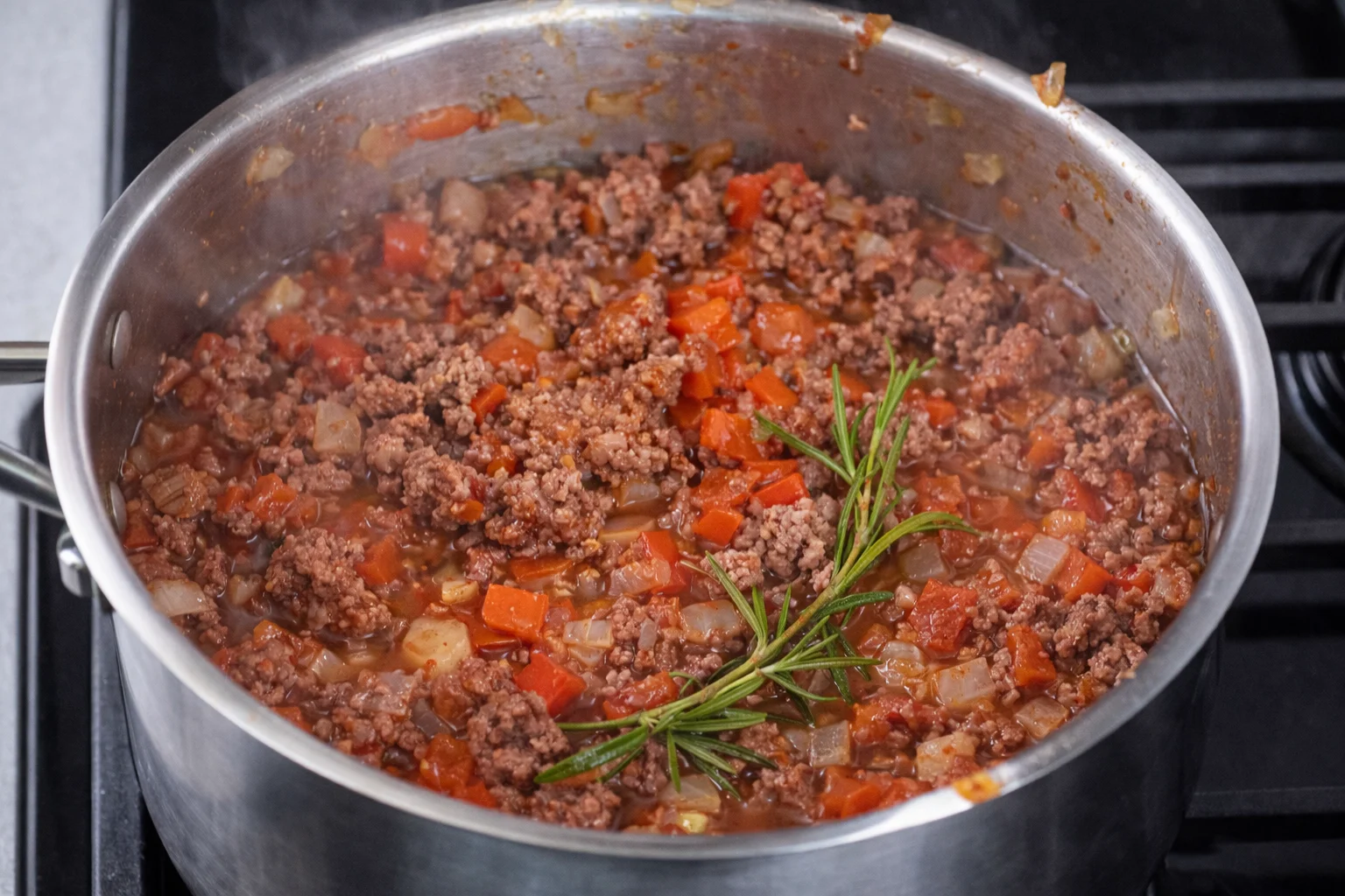ground beef tomato sauce with onions and rosemary cooking in pan for casserole