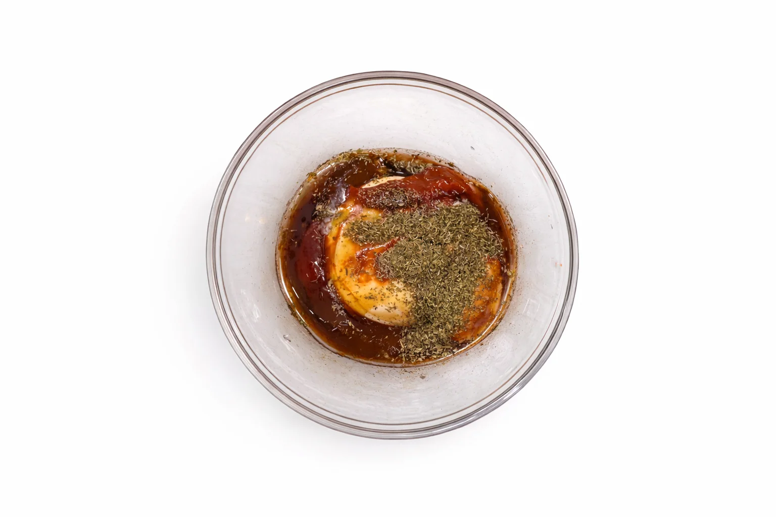 hot honey dijon dipping sauce with herbs mixed in a small bowl