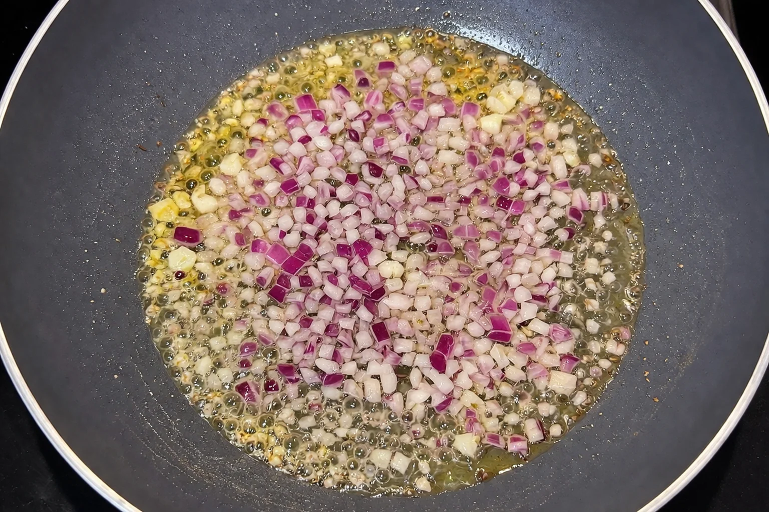 Onions and garlic sautéing in butter in a pan
